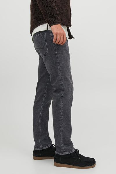 Jean droit noir de JACK & JONES JEANS INTELLIGENCE, porté avec un pull en laine bouclée et des chaussures en daim.
