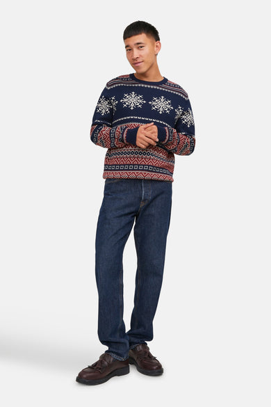 Pull bleu à col rond par ORIGINALS BY JACK & JONES avec motif de Noël, porté avec un jean foncé et des chaussures marron.