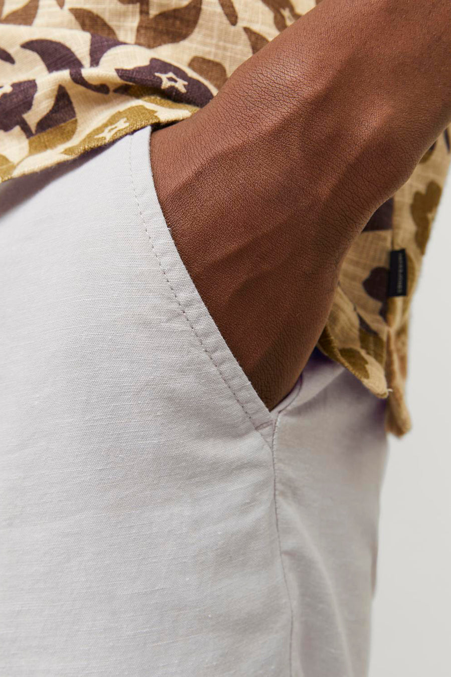 Short beige en lin by JACK & JONES JEANS INTELLIGENCE, détail de poche et motif du haut visible.
