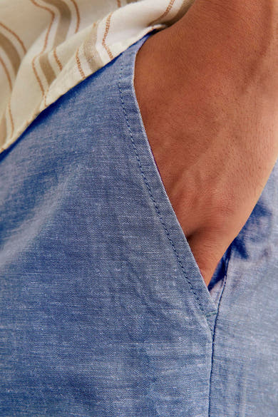 Short bleu JACK & JONES JEANS INTELLIGENCE avec une poche et une main à l'intérieur.