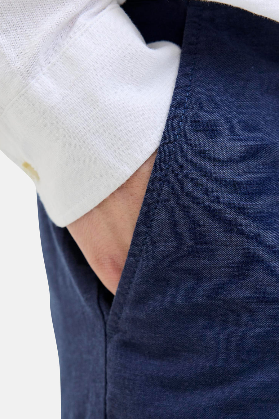 Short bleu de JACK & JONES JEANS INTELLIGENCE, avec une main dans la poche et une chemise blanche visible.
