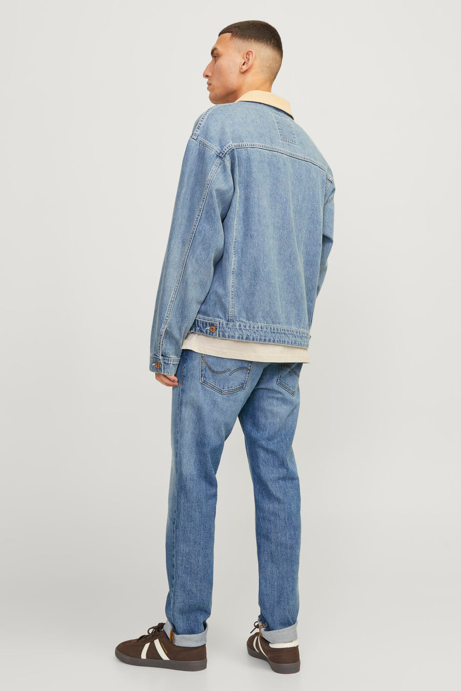 Jean droit en denim bleu moyen de JACK & JONES JEANS INTELLIGENCE, avec revers aux chevilles et chaussures marron.
