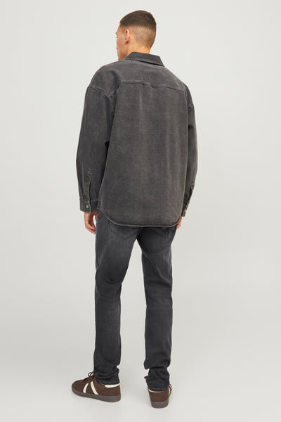 Jean slim noir de JACK & JONES JEANS INTELLIGENCE porté avec une chemise en denim gris anthracite et des baskets marron.