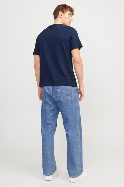 Navy blue short-sleeve t-shirt with round neckline, worn by model in back view with light wash denim jeans and white sneakers.