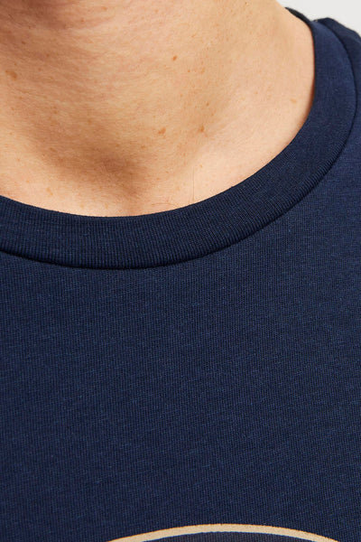Navy blue short-sleeve t-shirt with ribbed crew neckline, close-up front view showing textured knit fabric and partial circular design at bottom edge.