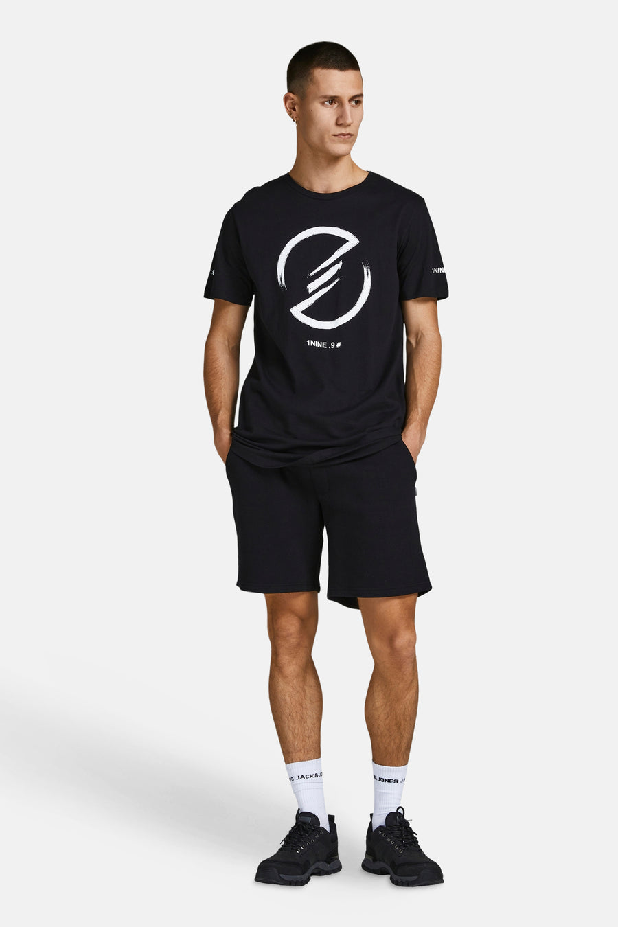 Korte noir van JACK & JONES JEANS INTELLIGENCE, gedragen met een zwart T-shirt en witte sokken.