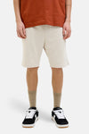 Korte ecru short van JACK & JONES JEANS INTELLIGENCE van fleece, gedragen met een roestkleurig T-shirt en sneakers.
