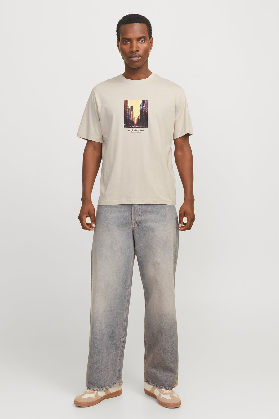 Ecru T-shirt met korte mouwen van ORIGINALS BY JACK & JONES met stadsprint, gedragen met een wijde jeans en sneakers.