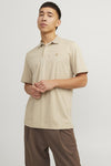 Beige polo van PREMIUM by JACK & JONES, gedragen met een bruine broek en bruine leren schoenen.