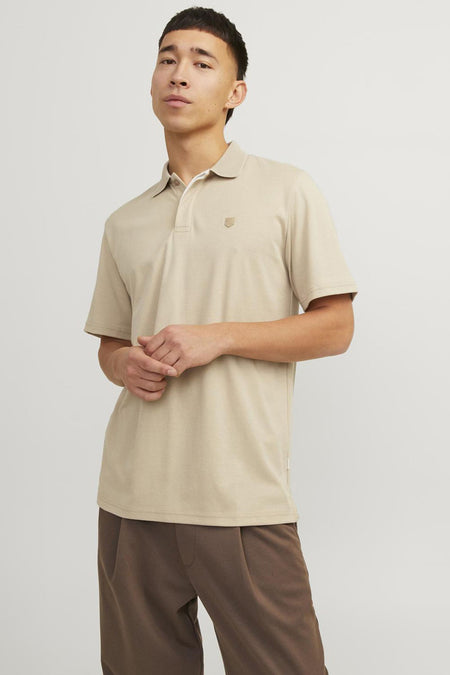Beige polo van PREMIUM by JACK & JONES, gedragen met een bruine broek en bruine leren schoenen.