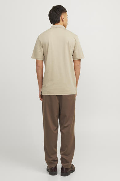 Polo beige de PREMIUM by JACK & JONES, porté avec un pantalon marron et des chaussures en cuir marron.