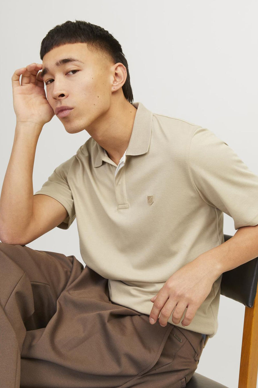 Beige polo van PREMIUM by JACK & JONES, getextureerde kraag, gedragen met een bruine broek.
