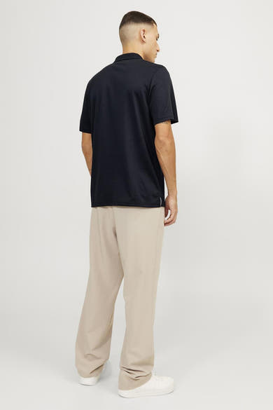Blauw poloshirt van PREMIUM by JACK & JONES, gedragen met een beige broek en witte sneakers, achtergezicht.