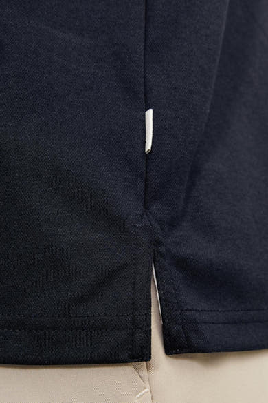 Marineblauwe polo van PREMIUM by JACK & JONES, zijsplitdetail met contrasterende binnenkant.