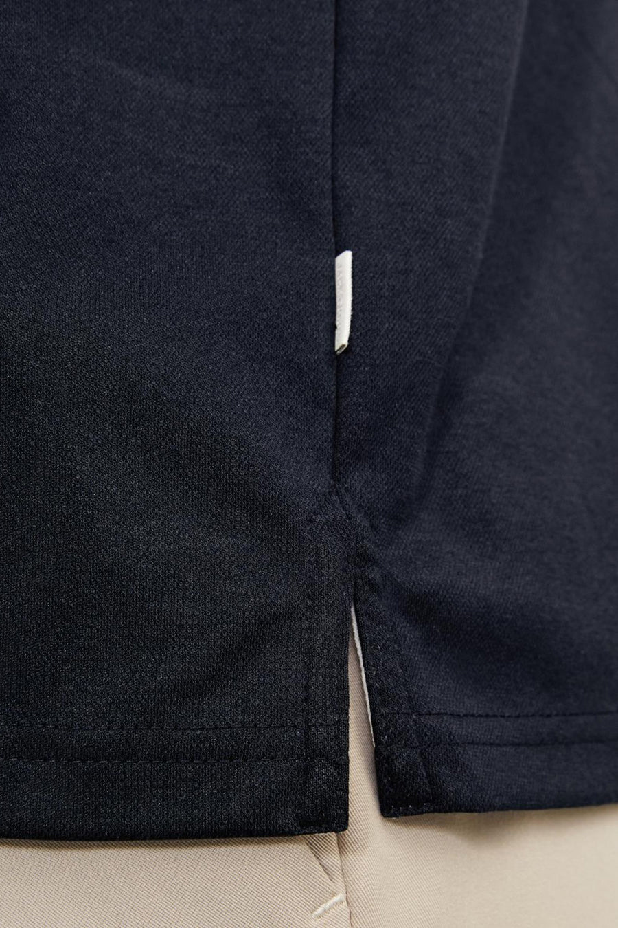 Marineblauwe polo van PREMIUM by JACK & JONES, zijsplitdetail met contrasterende binnenkant.