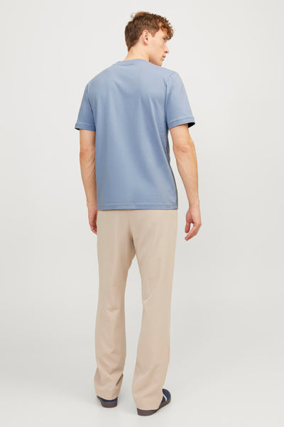 T-shirt bleu de PREMIUM by JACK & JONES, porté avec un pantalon beige, vue de dos.

