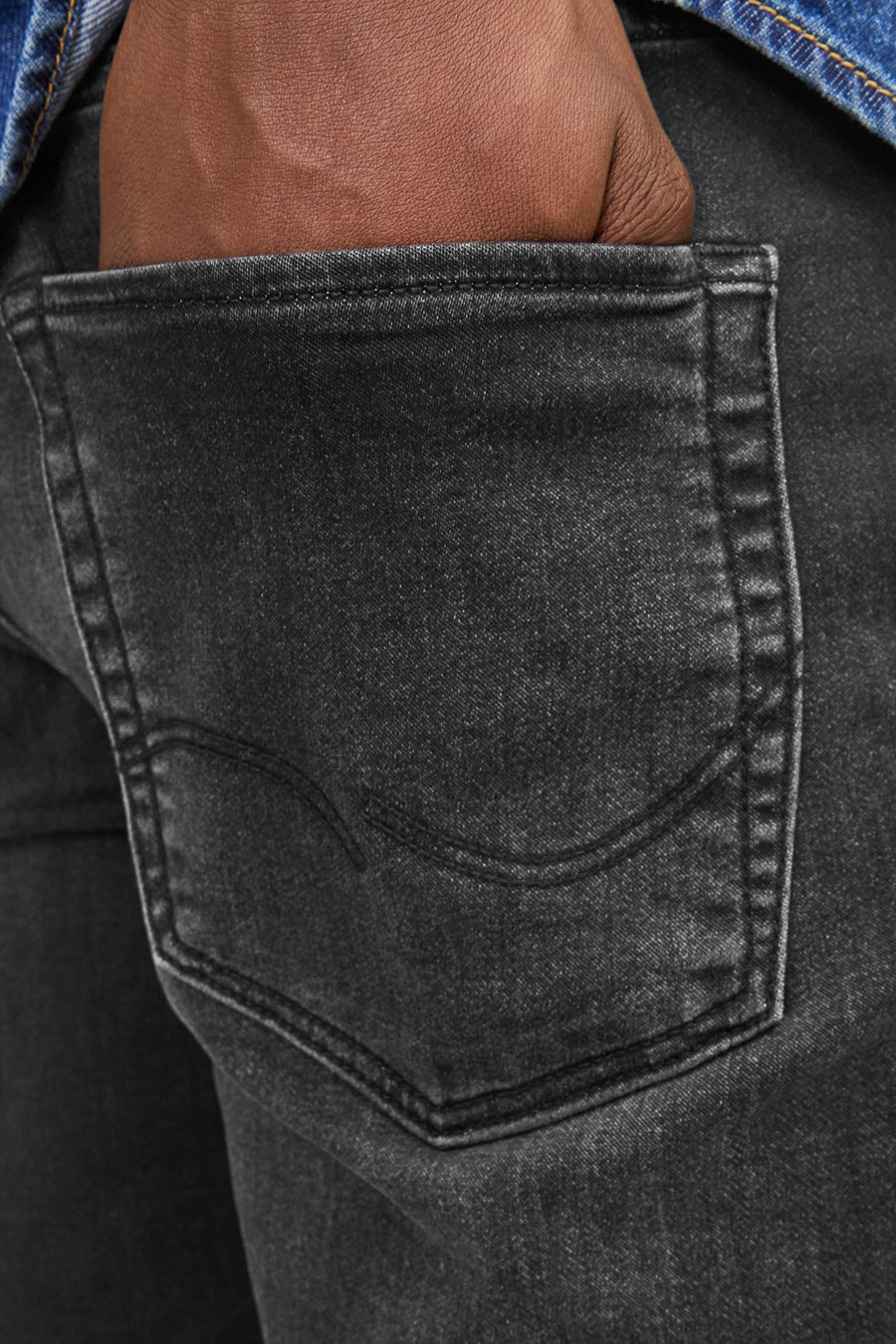 Short en denim noir de JACK & JONES JEANS INTELLIGENCE avec une main dans la poche arrière.