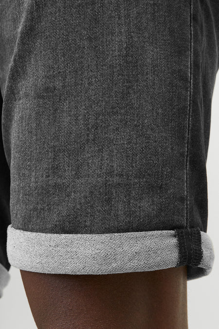 Korte zwarte spijkerbroek van JACK & JONES JEANS INTELLIGENCE met een hand in de achterzak.