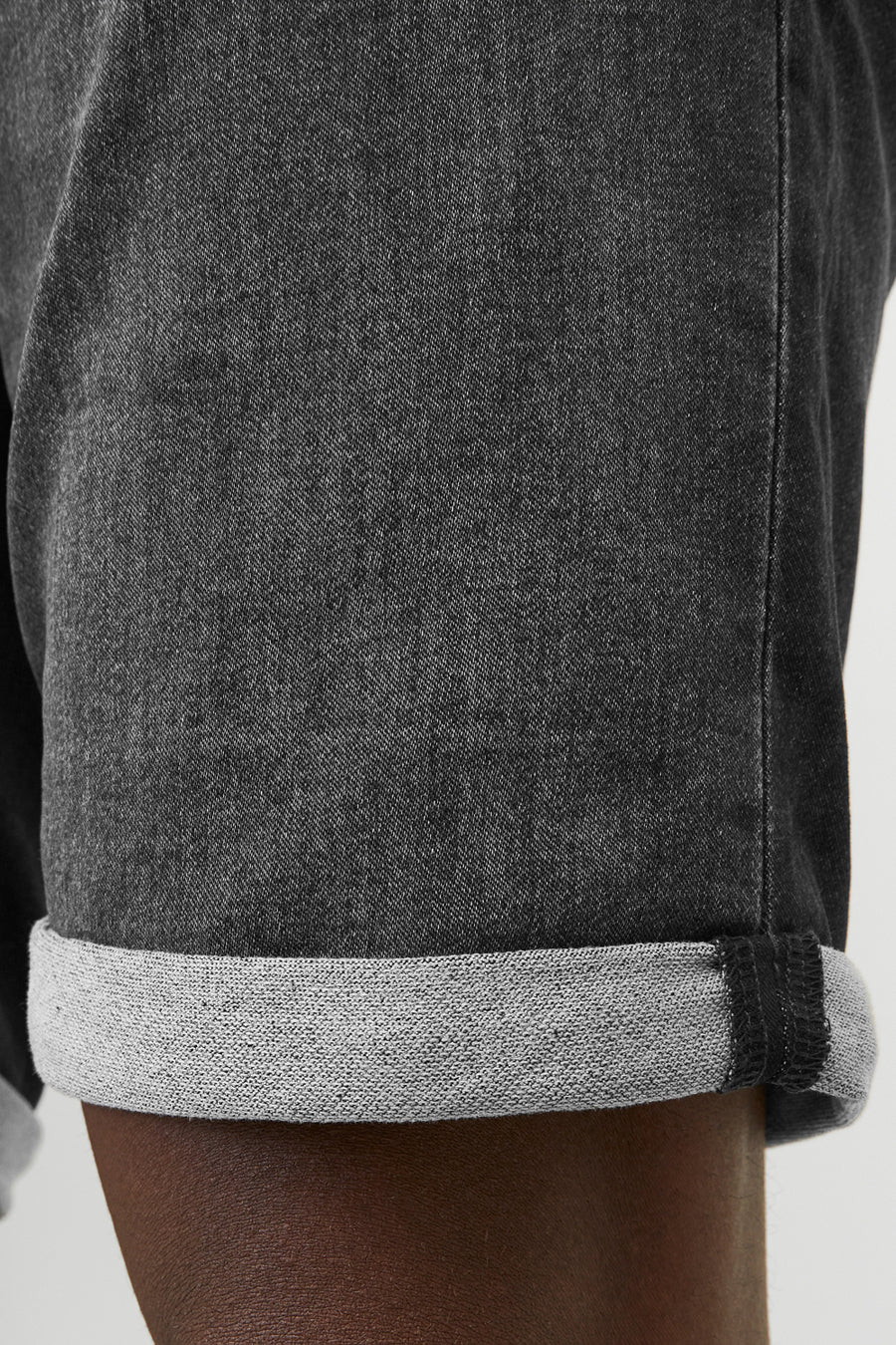 Korte zwarte spijkerbroek van JACK & JONES JEANS INTELLIGENCE met een hand in de achterzak.