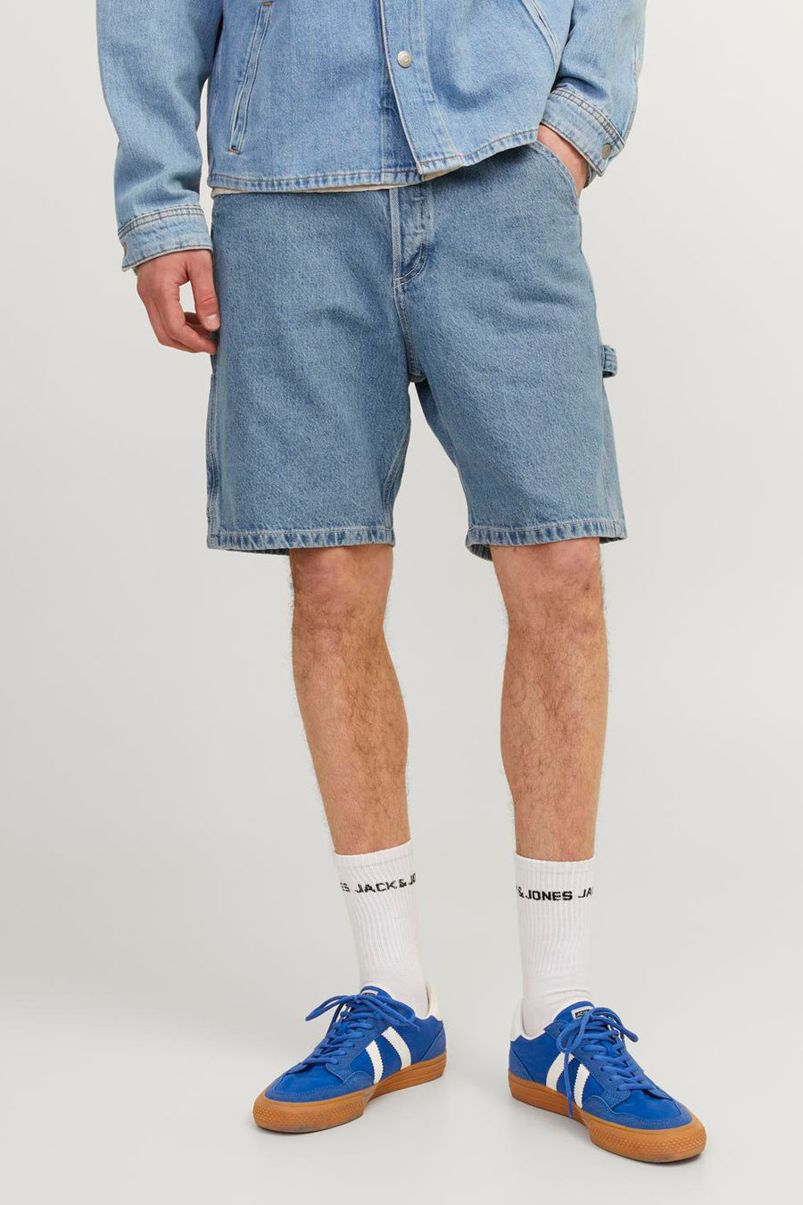 Short en jean bleu clair de JACK & JONES, porté avec des chaussettes blanches et des baskets bleues.