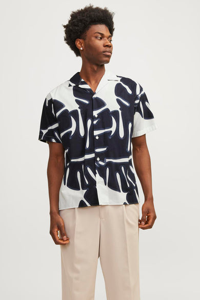 Chemise à manches courtes à motif blanc de PREMIUM by JACK & JONES portée avec un pantalon beige.
