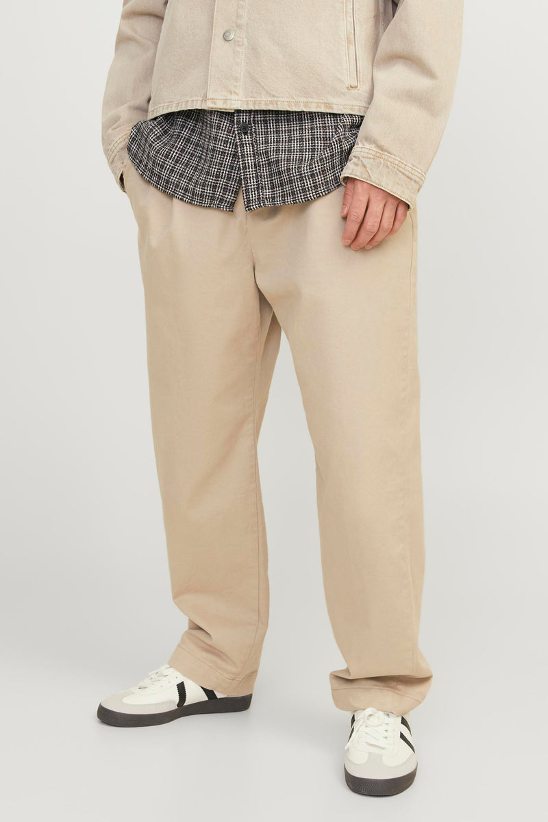 Pantalon écru de JACK & JONES JEANS INTELLIGENCE, porté avec une chemise à carreaux et un blouson beige.