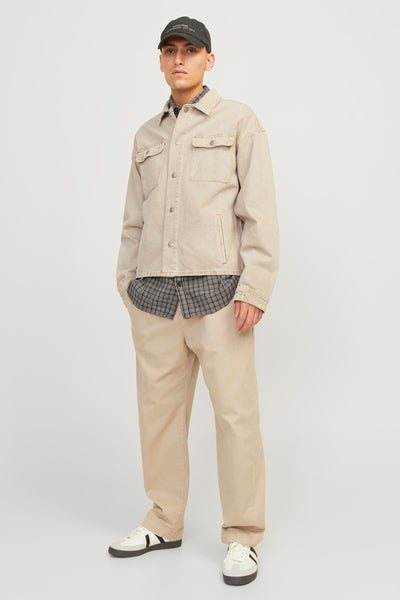 Pantalon de saison écru de JACK & JONES JEANS INTELLIGENCE, porté avec une chemise à carreaux et une veste beige.