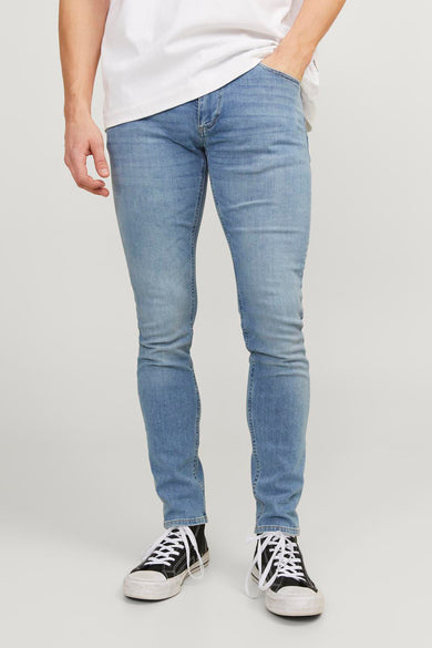 Jean skinny bleu clair de JACK & JONES JEANS INTELLIGENCE porté avec un t-shirt blanc et des baskets noires.