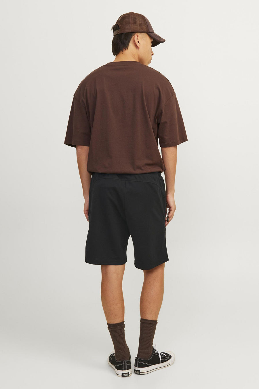 Korte zwarte broek van JACK & JONES JEANS INTELLIGENCE, gedragen met bruin T-shirt, zwarte sokken en schoenen.