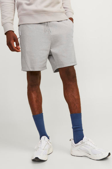 Short gris de JACK & JONES JEANS INTELLIGENCE porté avec des chaussettes bleues et des baskets blanches.