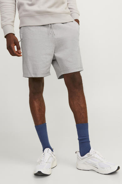 Grijs jersey short van JACK & JONES JEANS INTELLIGENCE, gedragen met een trui en witte sneakers.