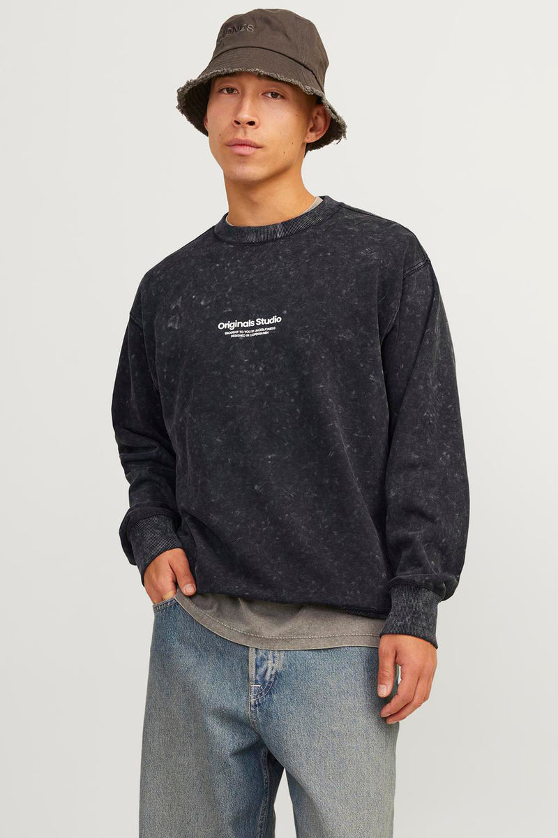 Polaire noir Originals by Jack & Jones, effet délavé, porté avec un jean bleu et un bob marron.