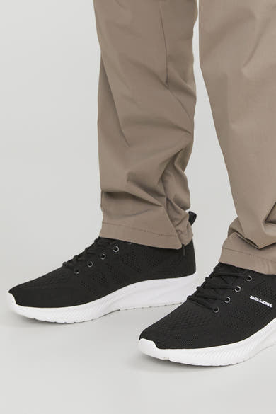 Grijze sneakers van ACCESSORIES BY JACK & JONES, met witte zool en zwarte veters, gedragen met een kaki broek.