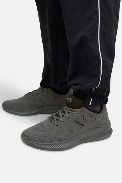 Grijze sneakers van ACCESSORIES BY JACK & JONES, mesh-patroon, gedragen met een zwarte gestreepte broek.