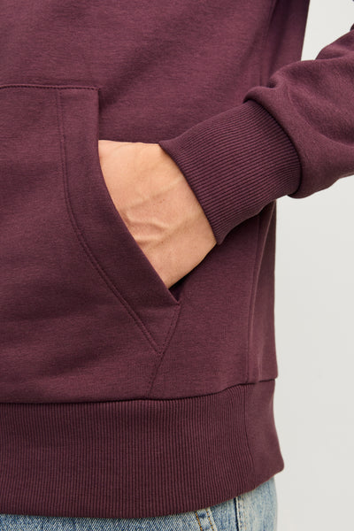 Sweat à capuche rouge bordeaux de ORIGINALS BY JACK & JONES, avec une main dans la poche avant.