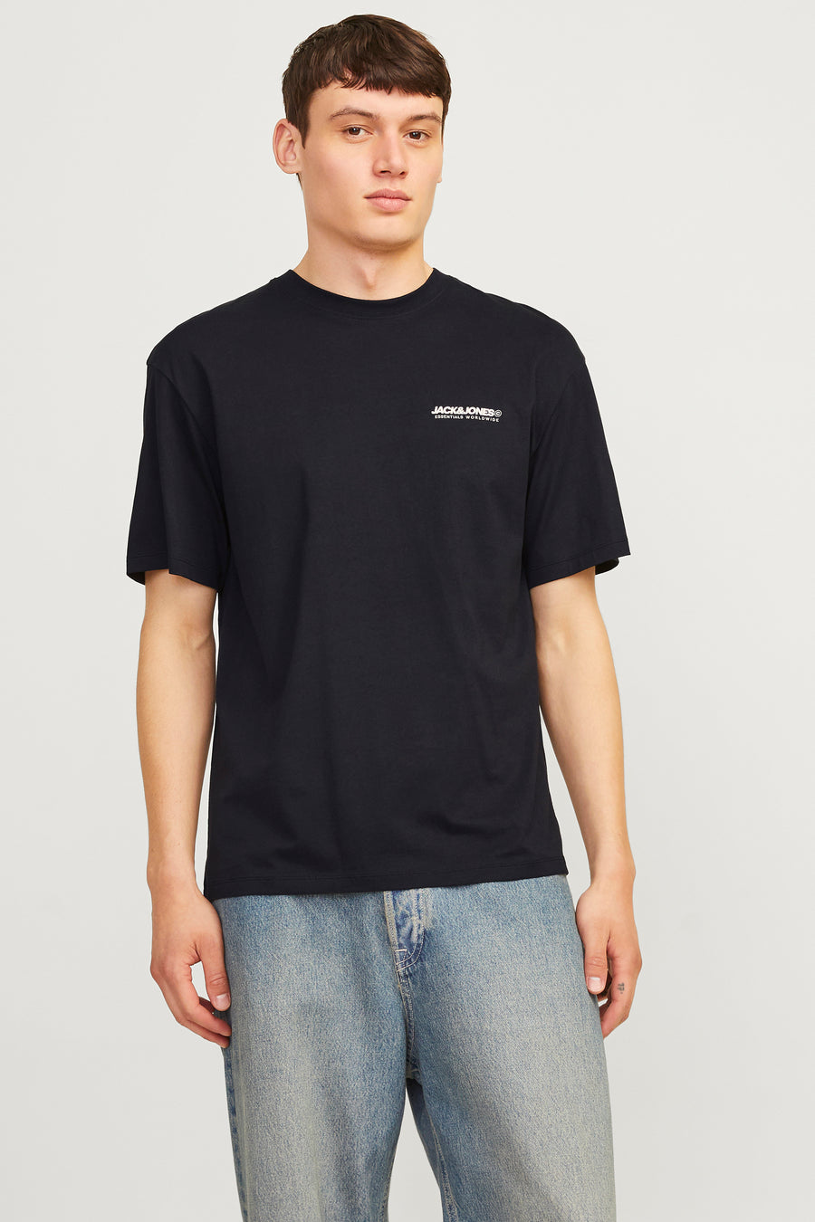 Zwart T-shirt met korte mouwen van Jack & Jones, gedragen met een wijde jeans en sneakers.