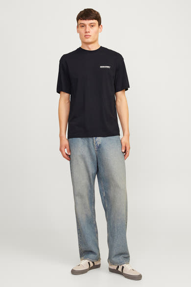T-shirt à manches courtes noir de Jack & Jones, porté avec un jean ample et des baskets.
