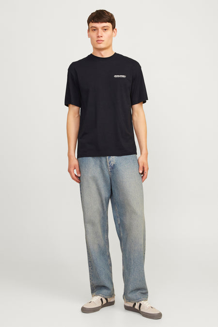 T-shirt à manches courtes noir de Jack & Jones, porté avec un jean ample et des baskets.
