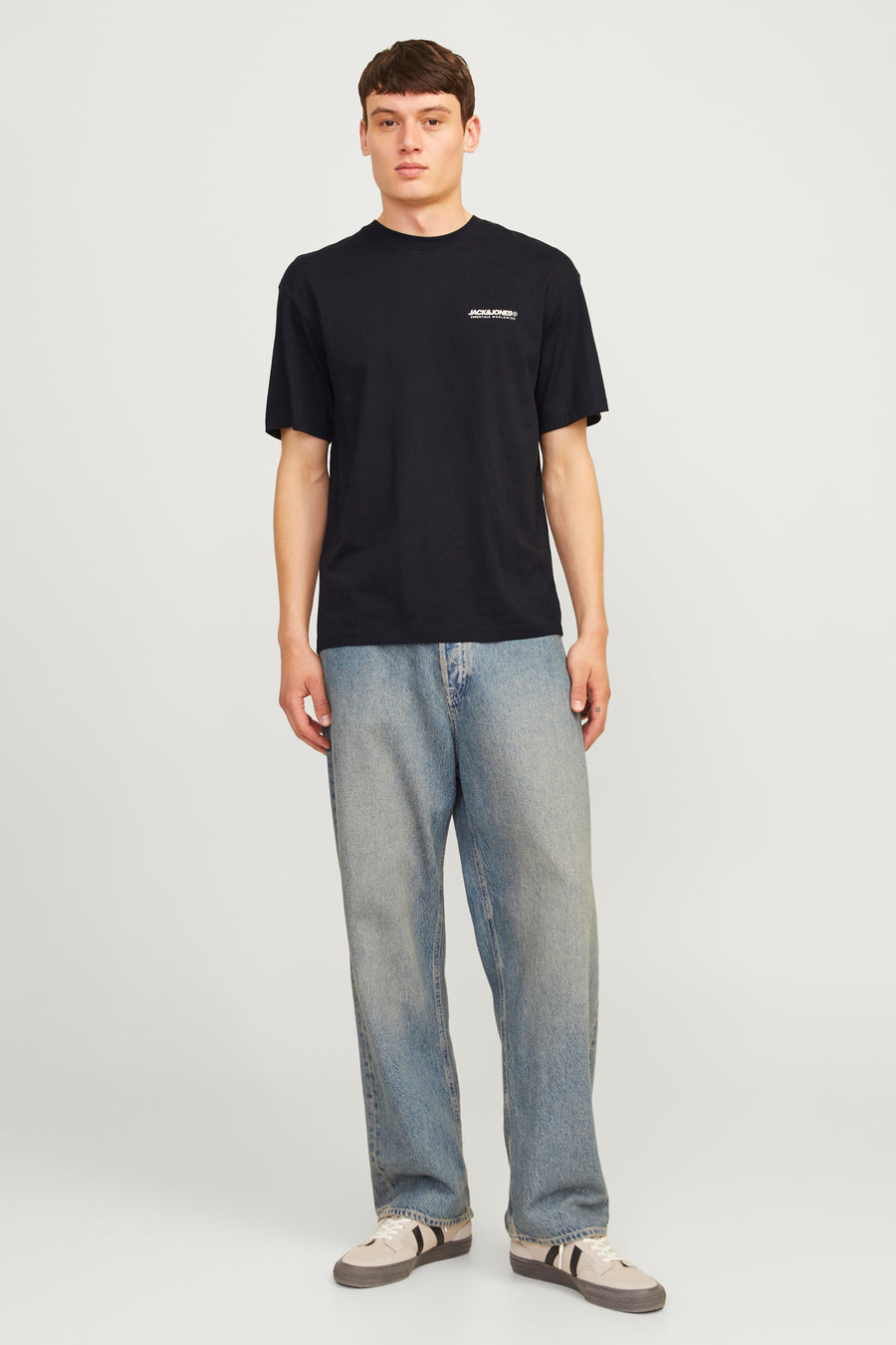 T-shirt à manches courtes noir de Jack & Jones, porté avec un jean ample et des baskets.
