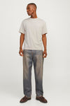 Beige T-shirt met korte mouwen van JACK & JONES, gedragen met een wijde, verbleekte spijkerbroek en bruine loafers.