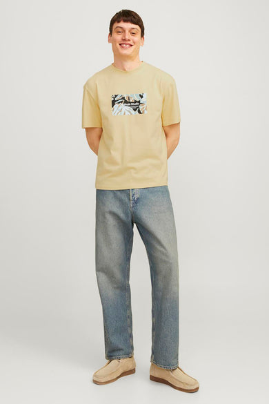 T-shirt jaune à manches courtes d'ORIGINALS BY JACK & JONES, avec un imprimé graphique sur la poitrine, porté avec un jean et des chaussures décontractées.