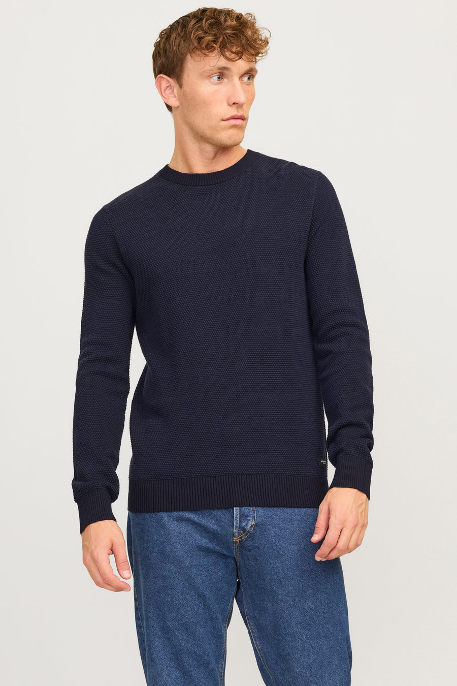 Pull à col rond bleu by JACK & JONES, porté avec un jean bleu.