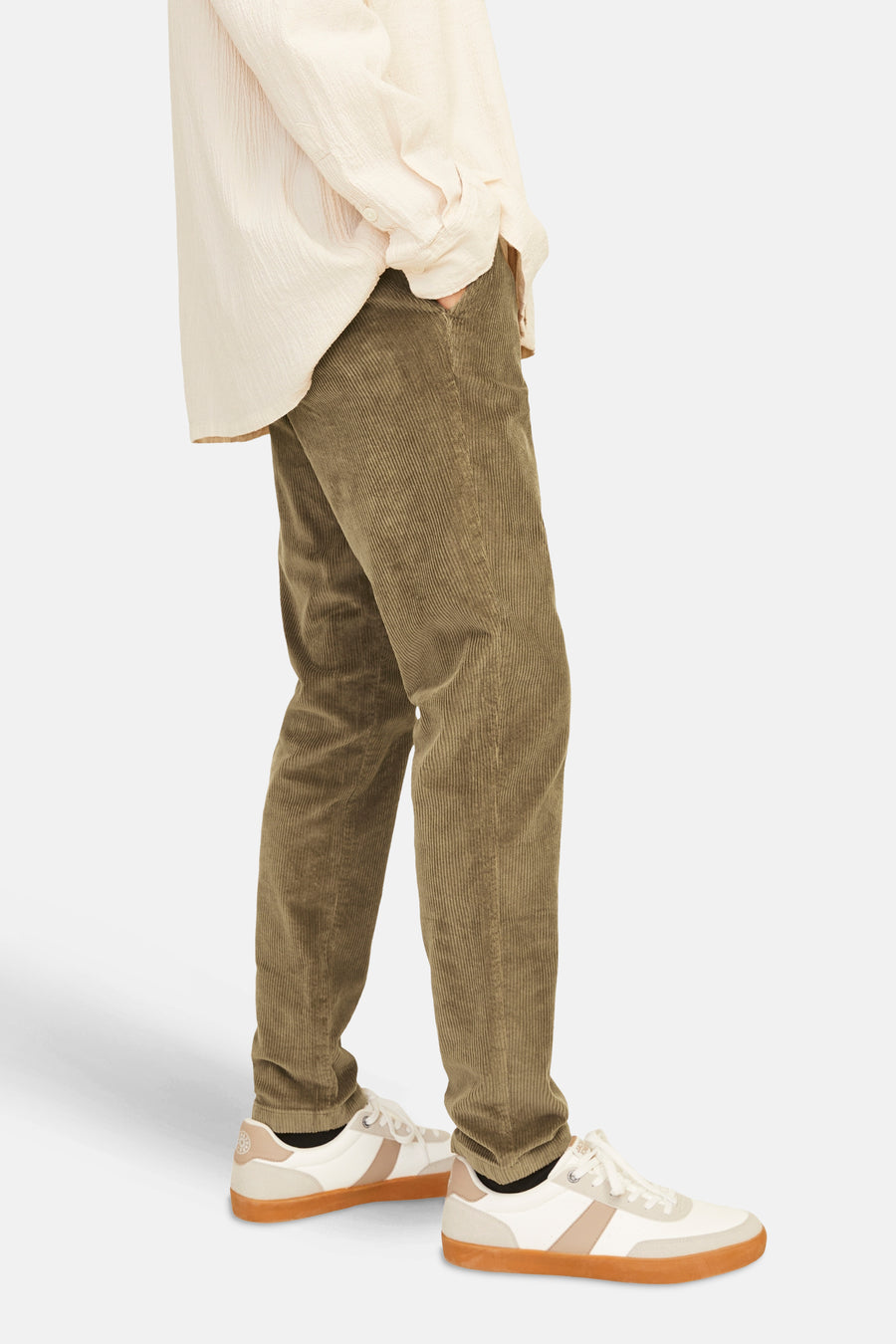 Pantalon de saison en velours côtelé brun de JACK & JONES, porté avec une chemise couleur crème et des baskets blanches.