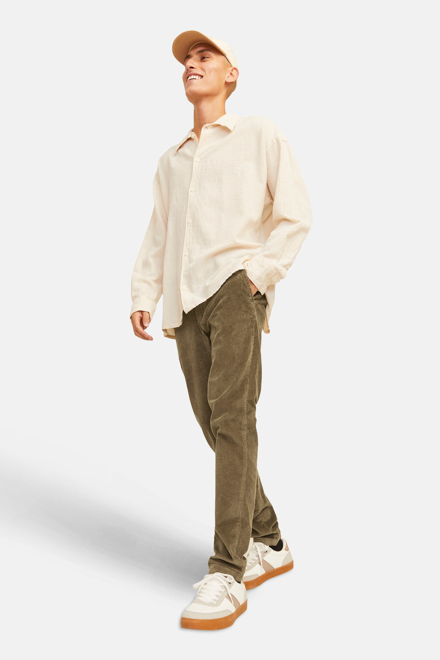 Pantalon en velours côtelé brun de JACK & JONES JEANS INTELLIGENCE, porté avec une chemise beige et des baskets blanches.