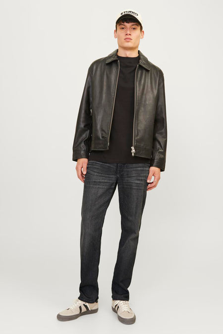 Jean droit noir de JACK & JONES JEANS INTELLIGENCE porté avec une veste en cuir et des baskets beiges.