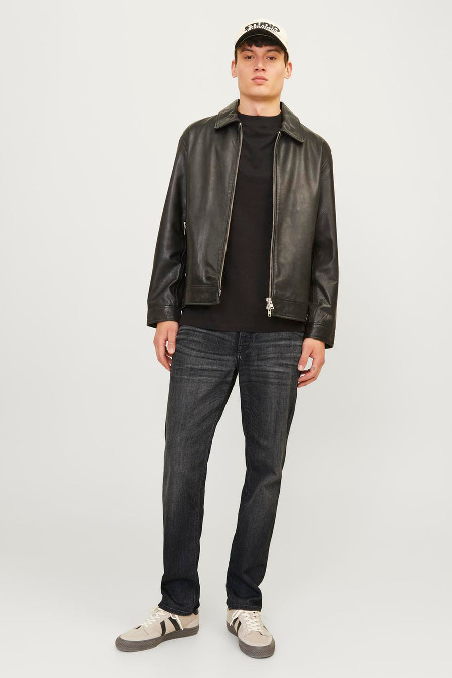 Zwarte rechte jeans van JACK & JONES JEANS INTELLIGENCE gedragen met een leren jasje en beige sneakers.