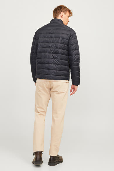 Korte zwarte jas, ORIGINALS BY JACK & JONES, gedragen met een beige broek en bruine laarzen, van achteren gezien.