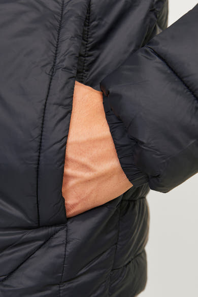 Korte zwarte jas van ORIGINALS BY JACK & JONES met één hand in de zak.