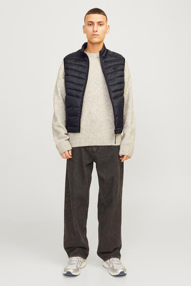 Zwart mouwloos jack van ORIGINALS BY JACK & JONES, gedragen met een beige trui en een donkergrijze broek.