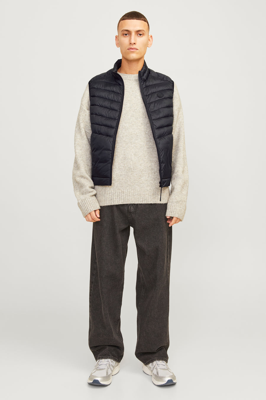Zwart mouwloos jack van ORIGINALS BY JACK & JONES, gedragen met een beige trui en een donkergrijze broek.